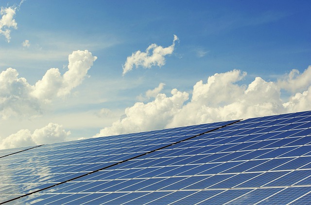 Aerial view of solar panels on farm buildings surrounded by green agricultural fields